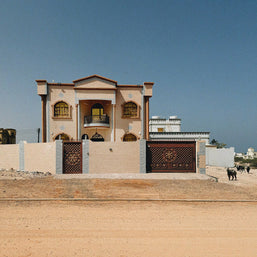 Goat Guards, Muscat, Omã 2026, por Fabiana Kocubey — fachada urbana com placa ou facçada característica de Muscat, cena de rua inusitada e colorida do dia a dia omãnita. Pôster vertical estilo museu, FK Prints. | Goat Guards, Muscat, Oman 2026, by Fabiana Kocubey — an urban facade or signage scene from Muscat, an unusual and colorful slice of everyday Omani street life. Museum-style vertical poster, FK Prints.
